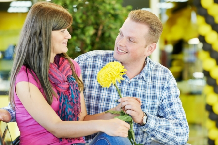 Happy smiling man and woman on a date with flowerの写真素材