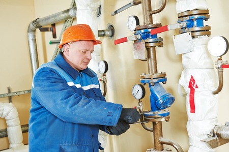 repairman engineer of fire engineering system or heating system open the valve equipment in a boiler houseの写真素材