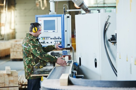Worker of wood processing manufacture operating on woodworking machineの写真素材
