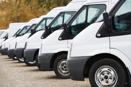 commercial delivery vans in row at parking place of transporting carrier shipping service companyの写真素材