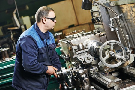 milling machine operator working in factory workshop