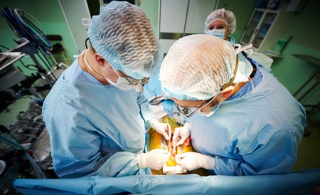 Team of surgeon in uniform perform heart transplantation operation on a patient at cardiac surgery...