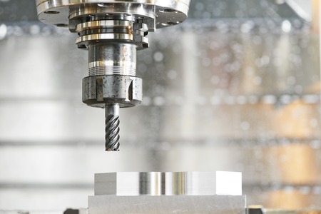 Milling machine tool with mill in chuck preparing to process metal detail at industrial manufacture...
