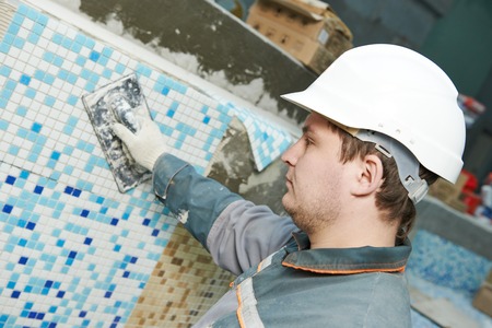 industrial tiler builder worker installing floor tile at repair renovation work