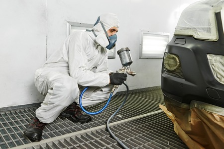 automobile repairman painter painting car body bumper in chamberの写真素材