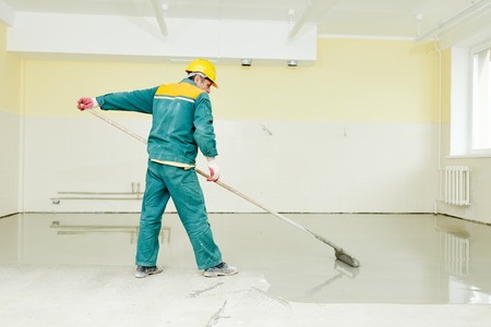 plasterer during floor covering works with self-levelling cement mortarの写真素材