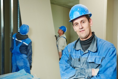 cheerful plasterboard workers team at a indoors wall insulation works