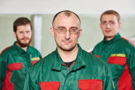 Group portrait of service repairman in uniform in automobile service station garageの写真素材