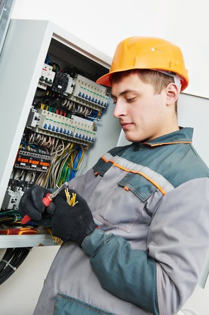 electrician builder engineer worker working with cable in fuse switch box