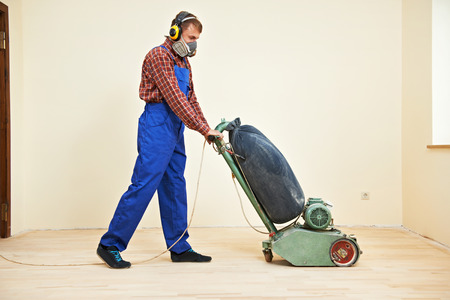 carpenter doing parquet Wood Floor polishing maintenance work by grinding machineの写真素材