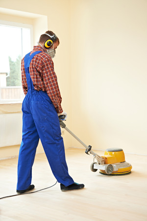 carpenter doing parquet Wood Floor polishing maintenance work by grinding machineの写真素材