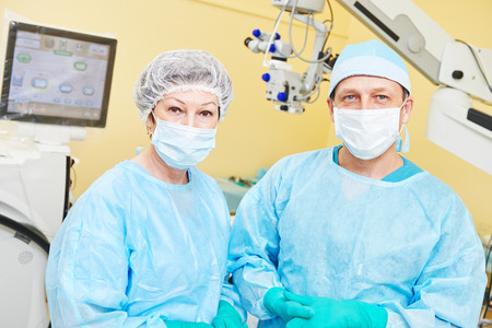 surgeon team in uniform in front of eye vision surgery operation room at medical clinicの写真素材