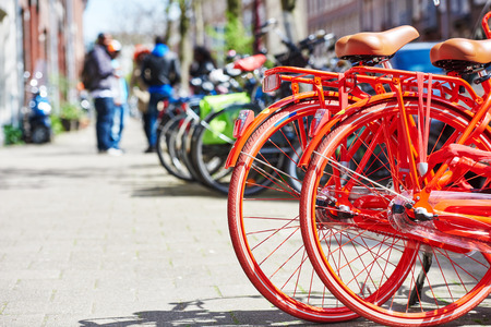 Two red bicycle on the city street near hotel in Amsterdamの写真素材