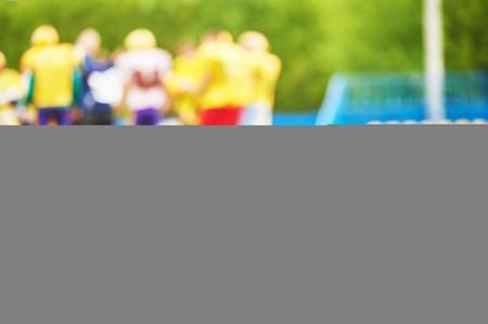 American football ball with training equipment lying on field grassの写真素材