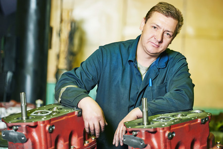 industrial worker assembler portrait with gearbox utits at manufacture workshop
