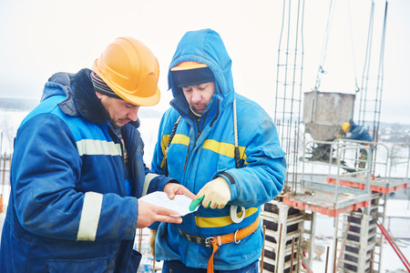 two construction builders workers during concrete work at building siteの写真素材