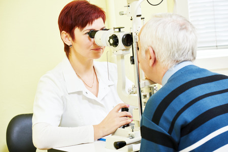 Optometry concept. female optometrist optician doctor examines eyesight of female patient in eye ophthalmological clinicの写真素材