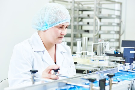 pharmaceutical factory woman worker operating production line at pharmacy industry manufacture...