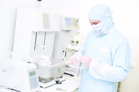 Pharmaceutical scientific male researcher in protective uniform working with friability, abrasion...