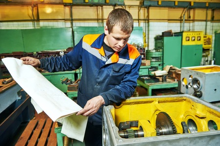 Adult experienced industrial worker assembling the reduction gear box on production line...