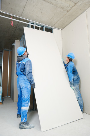 gypsum plasterboard installation during indoor walling by workersの写真素材