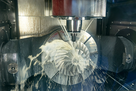 cnc metal working machining center with cutter tool during metal detail milling at factory....