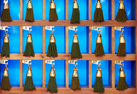 hotel keys with green tassels at reception desk counterの写真素材