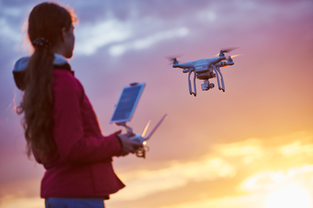 drone quadcopter flying or hovering by under remote control operation in sunset. Very shallow field...