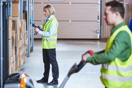 Warehousing. workers using wireless barcode scanner and fork stacker. Warehouse Management Systemの写真素材