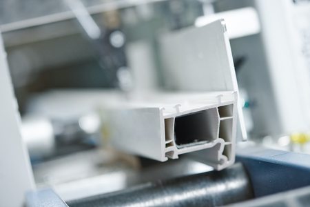 Plastic window and pvc door profile manufacturing. Production line with frame cut detail for double glazing. Macro. Shallow field of view.の写真素材
