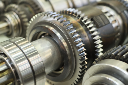 close-up metal cog wheels in gearing at gear box