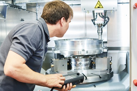 metal machining industry. Worker or service engineer operating cnc milling machine at factory