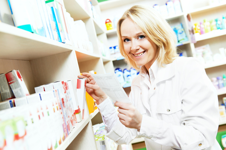 pharmacist chemist woman working in pharmacy drugstore with doctor prescriptionの写真素材