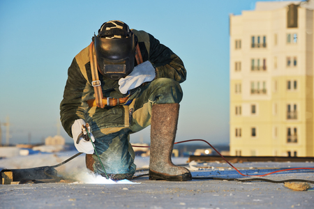 welder working with electrode at arc welding in construction site winter outdoorsの写真素材
