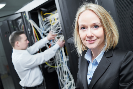 Happy female woman network engineer in server room with male colleague administratorの写真素材