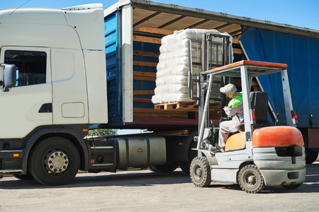 Loading works. Forklift loader moving pallet with load into cargo lorry truckの写真素材