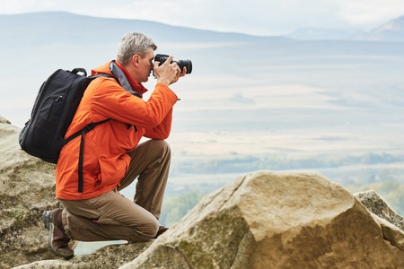 Professional photographer making landscape photos by digital mirror camera at georgia rock mountain