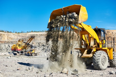 Heavy wheel loader extracting granite rock or iron ore at opencast mining quarryの写真素材