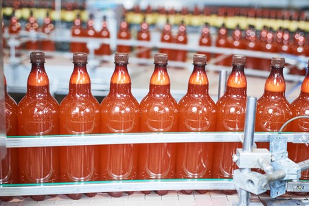 food and drink industry. Plastic bottles with beer or carbonated beverage moving on conveyorの写真素材