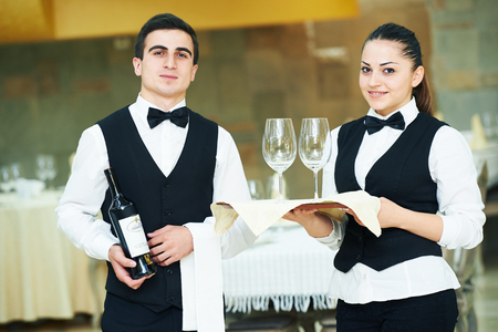 young waiter and waitress at service in restaurantの写真素材
