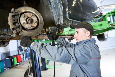 Auto repair service. Mechanic works with car suspensionの写真素材