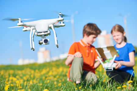children operating of flying drone at sunsetの写真素材