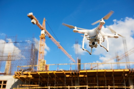 Drone hovering over construction site. video surveillance or industrial inspectionの写真素材