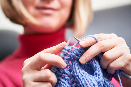Knitting. female hands with needle and threadの写真素材