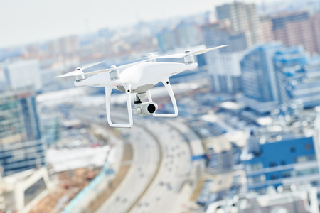 drone with digital camera hovering over cityの写真素材