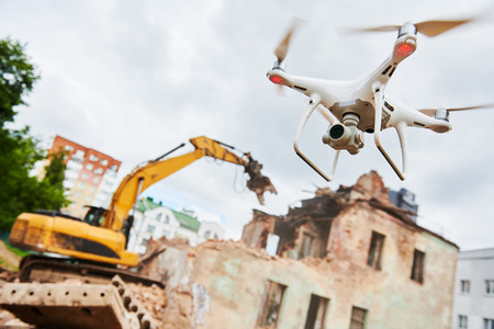 Drone operated by construction worker on building siteの写真素材
