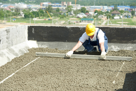 Roof construction. worker roofer leveling with float luteの写真素材