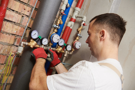 plumber installing and mounting water equipment - meter, filter and pressure reducer
