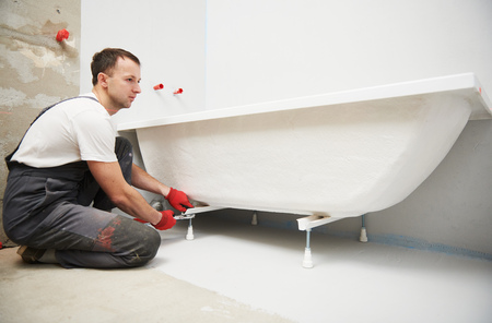 bathtube installation. plumber installing and mounting bathの写真素材