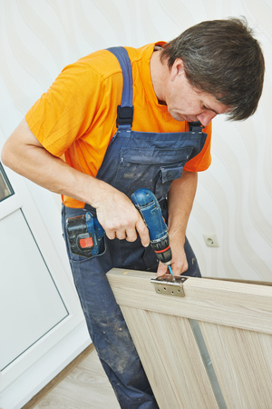 Door. installation. Carpenter works with drillの写真素材